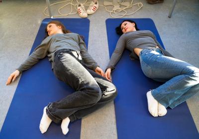 To piger laver yogaøvelser på måtter