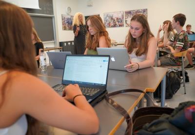 En klasse har AP i et lokale på Borupgaard Gymnasium. To elever rækken hånden i vejret, mens læreren står ved tavlen.