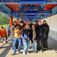 Ni kinesiskelever står samlet og smiler til kameraet ved Himlens Tempel