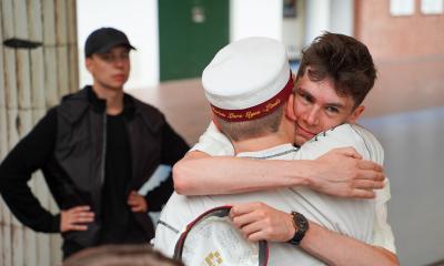 En drengestudent giver en anden drengestudent et kram.